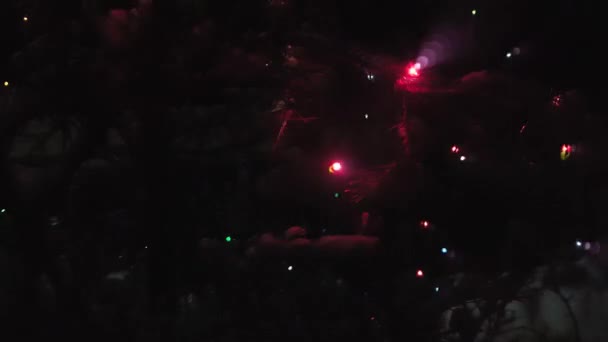 Árvore de Natal brilha com luzes coloridas. À espera do Natal no escuro — Vídeo de Stock