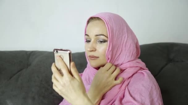 Арабская женщина в хиджабе в видеочате со своими друзьями по мобильному телефону — стоковое видео
