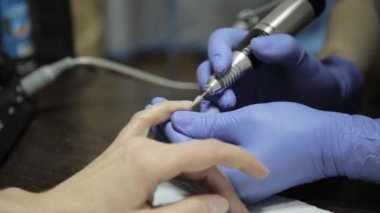 manikürcü tırnak salonu içinde kadın müşteri için profesyonel jel Lehçe Manikür yapıyor. kadın eğe talaşı çivi