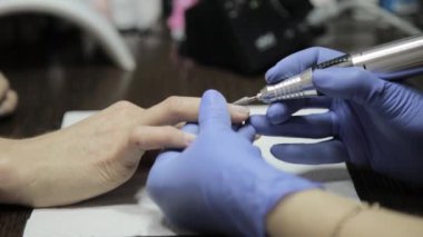 manikürcü tırnak salonu içinde kadın müşteri için profesyonel jel Lehçe Manikür yapıyor. kadın eğe talaşı çivi
