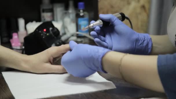 Manicura que hace la manicura profesional del esmalte del gel al cliente femenino en salón de uñas. mujer limaduras uñas — Vídeo de stock