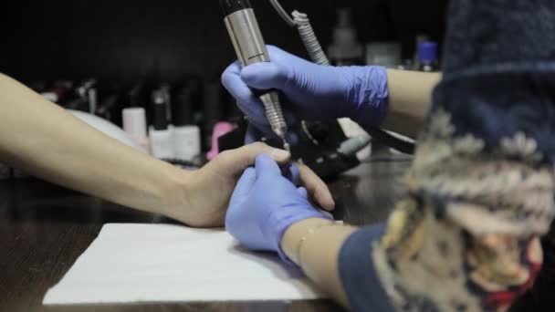 Manicura que hace la manicura profesional del esmalte del gel al cliente femenino en salón de uñas. mujer limaduras uñas — Vídeos de Stock