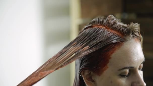 Cabeça de uma mulher bonita com pêssego tintura de cabelo em um salão de beleza — Vídeo de Stock