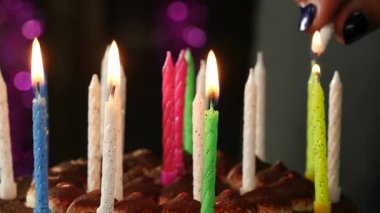 Yakın çekim kadın lezzetli doğum günü pastası mum ışıkları. Ağır çekim