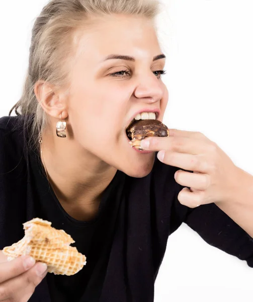 Mujer joven comiendo magdalenas con placer después de una dieta — Foto de Stock