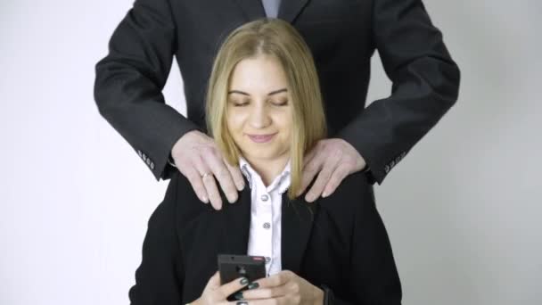 実業家は電話で selfie、従業員は長い仕事の後彼女の肩と首をマッサージ — ストック動画