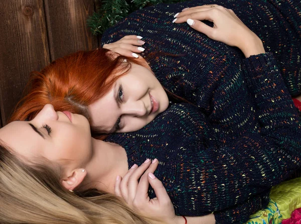 Duas lésbicas bonitas namoradas beijando e abraçando em uma atmosfera acolhedora — Fotografia de Stock