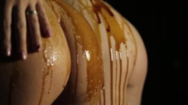 iki güzel kız kendilerini onlara bal ile eşek karanlık bir arka plan üzerinde rub