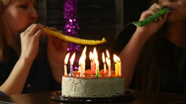 Two happy emotional woman blowing out the candles on a birthday cake, candles extinguished. slow motion — Stock Video