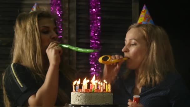 Dwa szczęśliwą kobietą emocjonalne zdmuchujące świeczki na tort urodzinowy, zgaszone świece. zwolnionym tempie — Wideo stockowe