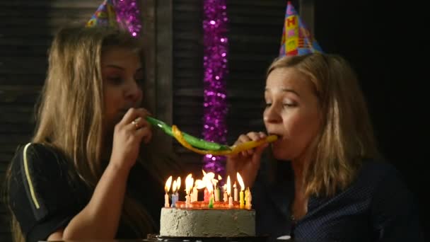 Dwa szczęśliwą kobietą emocjonalne zdmuchujące świeczki na tort urodzinowy, zgaszone świece. zwolnionym tempie — Wideo stockowe