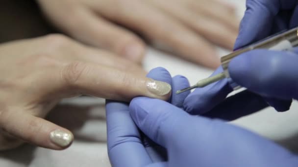 Kvinnans händer medan måla hennes naglar med röda polska i skönhetssalong — Stockvideo