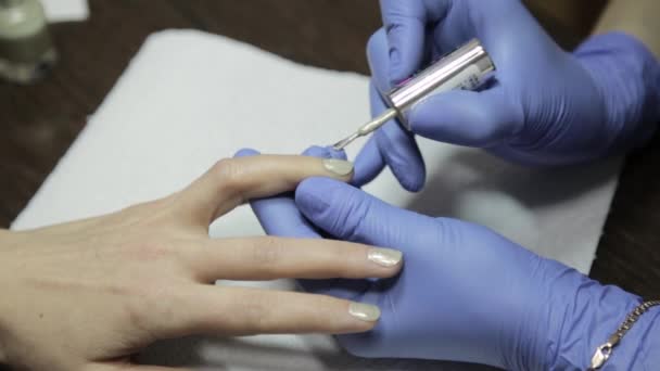 Kvinnans händer medan måla hennes naglar med röda polska i skönhetssalong — Stockvideo