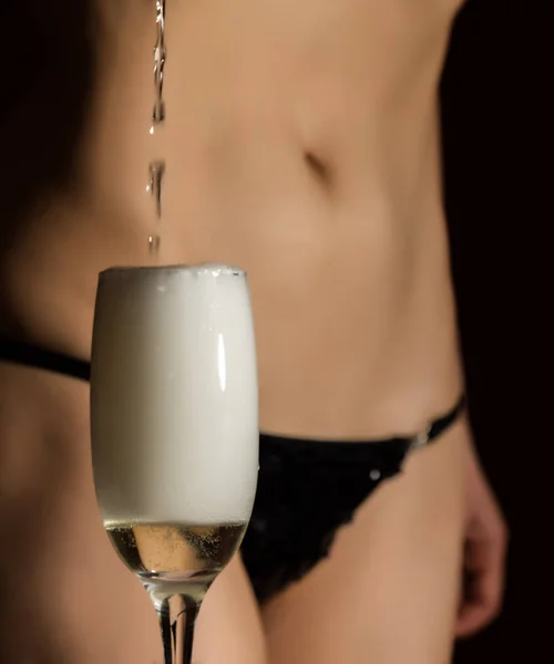 Sexy body woman in black underwear pours champagne in glass — Stock Photo, Image