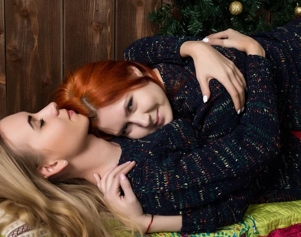 Duas lésbicas bonitas namoradas beijando e abraçando em uma atmosfera acolhedora — Fotografia de Stock