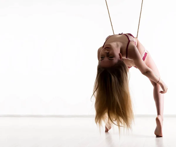 Perfect slank meisje met een touw poseren op een lichte achtergrond. Sexy atletisch lichaam. vrije ruimte voor uw tekst — Stockfoto