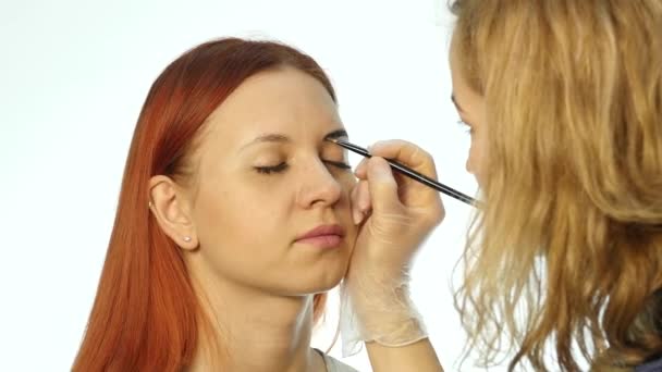 Maquillaje profesional artista dibujando cejas de hermoso cliente. Concepto de belleza y moda — Vídeos de Stock