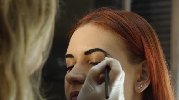 Επαγγελματία make-up artist σχεδίασης φρυδιών όμορφη πελάτη. Έννοια της ομορφιάς και μόδας — Αρχείο Βίντεο