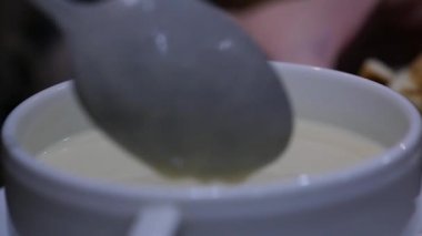 yakın çekim peynir çorbası croutons bir kapta, kız bir kaşıkla çorba kıpırdanırken. ağır çekim