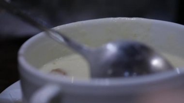 yakın çekim peynir çorbası croutons bir kapta, kız bir kaşıkla çorba kıpırdanırken. ağır çekim