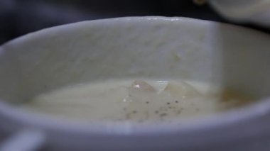 yakın çekim peynir çorbası croutons bir kapta, kız bir kaşıkla çorba kıpırdanırken. 4k