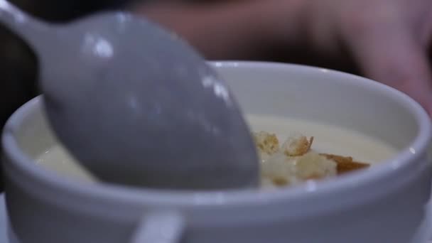 Primer plano sopa de queso en un tazón con croutons, chica revuelve sopa con una cuchara. cámara lenta — Vídeo de stock