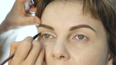 Göz kalemi göz kapağı üzerinde uygulama profesyonel makyöz close-up. moda endüstrisi kozmetik