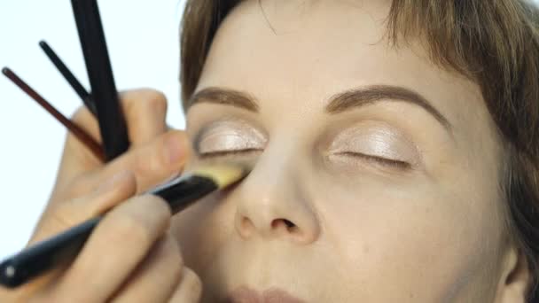 Close-up de maquilhador profissional aplicando delineador na pálpebra. indústria da moda cosméticos — Vídeo de Stock