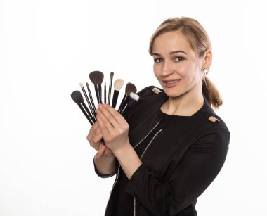 Makyaj fırçaları ile poz ve kamera isolatedon beyaz bir arka plan seyir neşeli güzel kadın