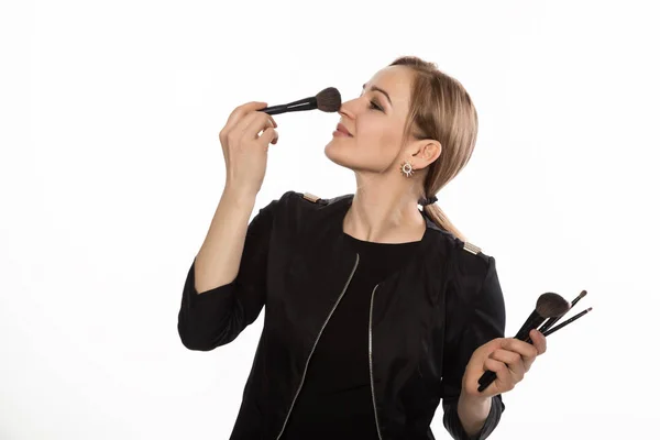 Vidám szép nő pózol, make-up ecset, és nézi a kamera isolatedon egy fehér háttér — Stock Fotó