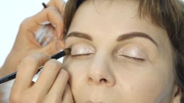 Göz makyaj kadın göz farı toz uygulamak. Stilist yapmak için erkek eyeliner tarafından yapıyor