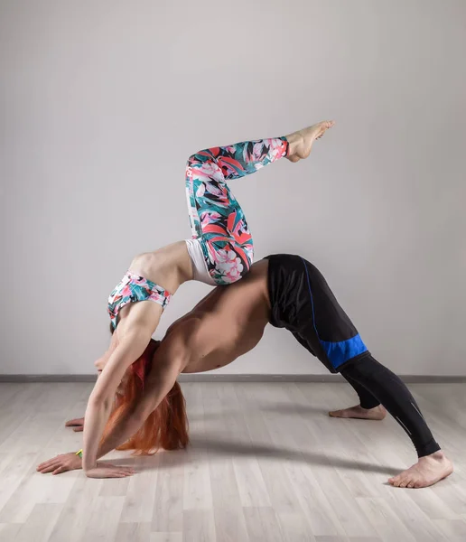 stock image sports man and woman doing acroyoga exercises in a dark room