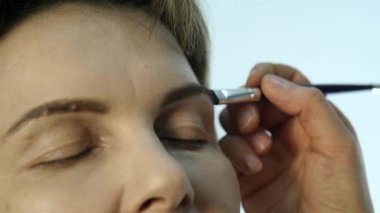 Göz makyaj kadın göz farı toz uygulamak. Stilist yapmak için erkek eyeliner tarafından yapıyor