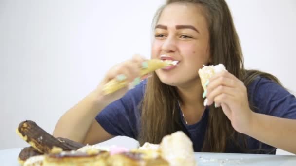 Νεαρή γυναίκα τρώει cupcakes με ευχαρίστηση μετά από μια δίαιτα — Αρχείο Βίντεο