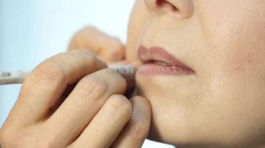 Profesyonel makyaj sanatçısı modeli dudaklarından kontur uygulamak. moda endüstrisi kozmetik