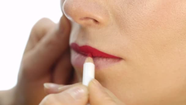 Artista de maquillaje profesional aplicando contorno en labios de modelo. cosméticos de la industria de la moda — Vídeos de Stock