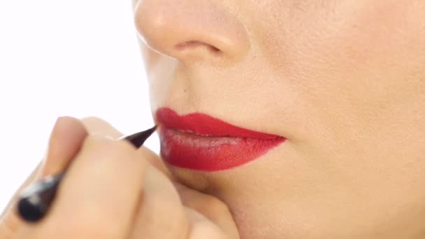 Artista de maquiagem profissional aplicando contorno nos lábios do modelo. indústria da moda cosméticos — Vídeo de Stock