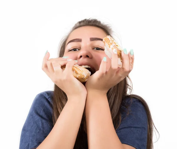 Mujer joven comiendo magdalenas con placer después de una dieta — Foto de Stock