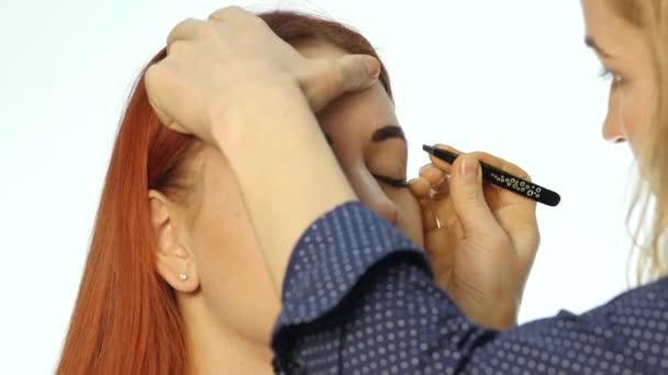 Maquilleuse professionnelle dessinant les sourcils d'un beau client. Concept beauté et mode — Video