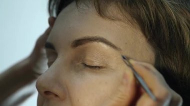 Göz kalemi göz kapağı üzerinde uygulama profesyonel makyöz close-up. Stilist yapmak için erkek eyeliner tarafından yapıyor