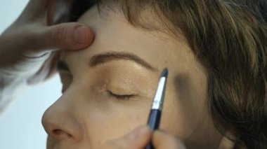 Göz kalemi göz kapağı üzerinde uygulama profesyonel makyöz close-up. Stilist yapmak için erkek eyeliner tarafından yapıyor