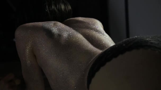 O artista de maquilagem aplica lantejoulas na pele de um modelo — Vídeo de Stock