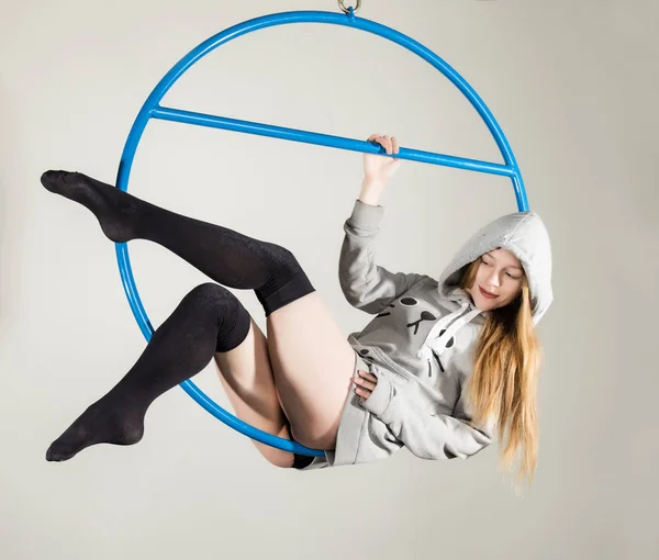 Acróbata aérea en un anillo. Una joven realiza elementos acrobáticos sobre un fondo blanco — Foto de Stock