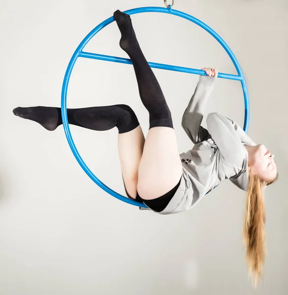Hava acrobat bir halkası üzerinde. Genç bir kadın akrobatik öğeleri beyaz bir arka plan üzerinde gerçekleştirir. — Stok fotoğraf