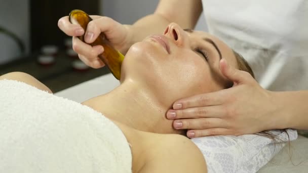 Massagista faz acupressão em um rosto feminino. Medicina alternativa chinesa. câmara lenta — Vídeo de Stock