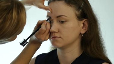 Göz makyaj kadın göz farı toz uygulamak. Stilist yapmak için erkek eyeliner tarafından yapıyor