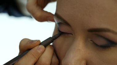 Göz makyaj kadın göz farı toz uygulamak. Stilist yapmak için erkek eyeliner tarafından yapıyor