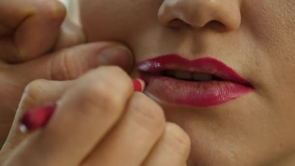 Artista de maquiagem profissional aplicando contorno nos lábios do modelo. indústria da moda cosméticos — Vídeo de Stock