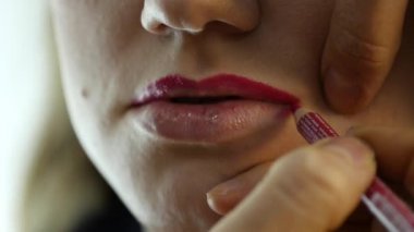 Profesyonel makyaj sanatçısı modeli dudaklarından kontur uygulamak. moda endüstrisi kozmetik