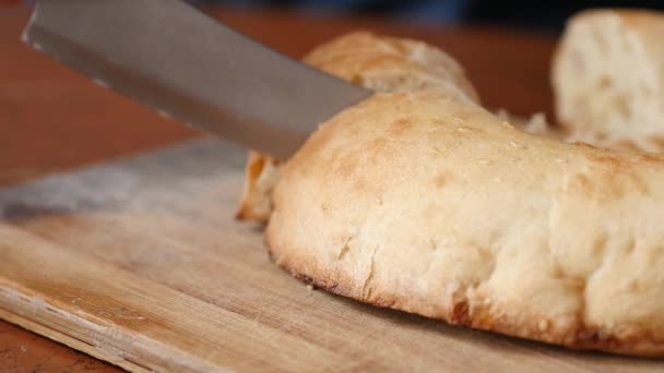 Pan blanco en rodajas en la tabla de cortar la cocina. Pan blanco suave recién horneado. cámara lenta — Vídeo de stock